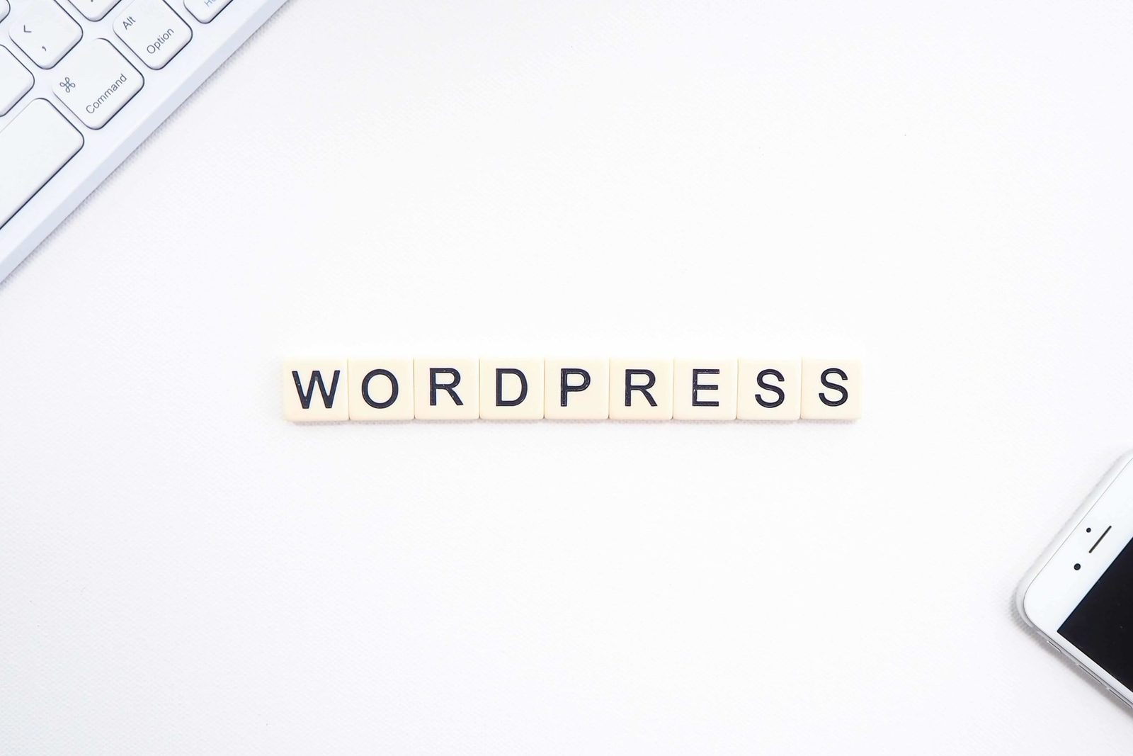 WORDPRESS spelled in letter tiles on a white desk
